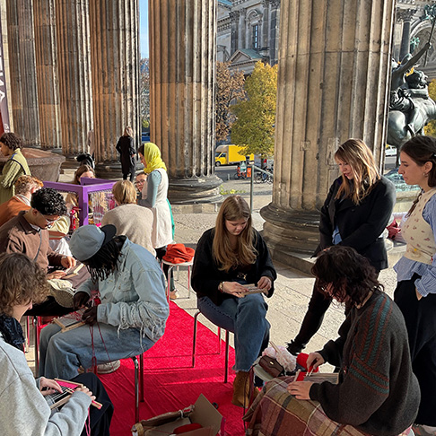 Gruppenfoto mit Jugendlichen zwischen antiken Säulen.